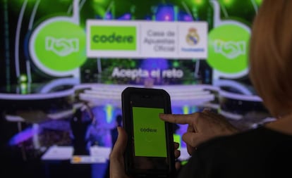Una joven utiliza un teléfono móvil con con una aplicación de apuestas online.