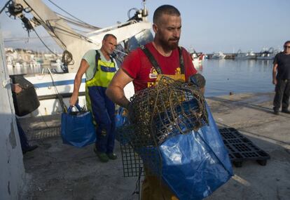 Dos marineros del Caleta Vélez descargan los plásticos hallados en caladeros para que personal de la Asociación Vertidos Cero lo segmente y gestione para su reciclaje.
