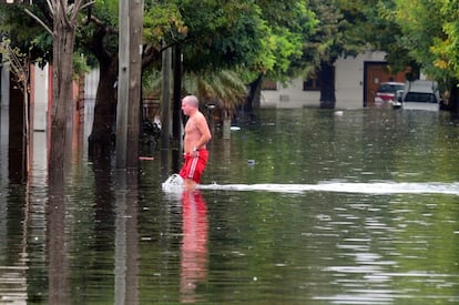 Un hombre camina por una calle inundada en La Plata (Argentina). Alrededor de 2.200 personas han sido evacuadas por el temporal.