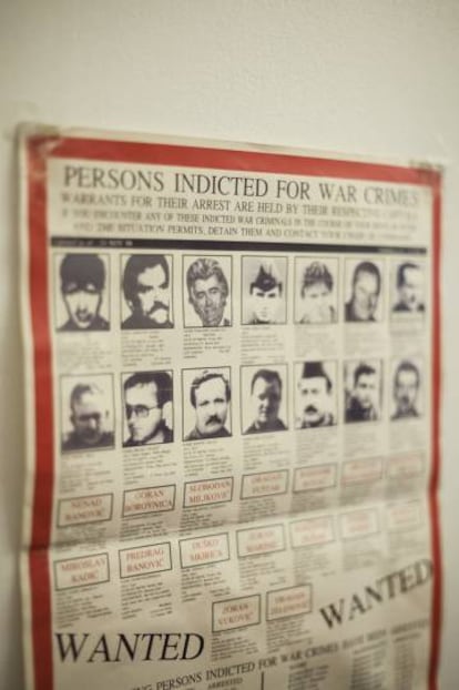 Vista del escritorio de Badet y cartel antiguo con fotografías de los criminales de guerra más buscados.