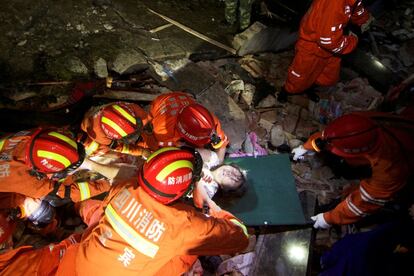 Los equipos de rescate colocan a una mujer en una camilla mientras buscan sobrevivientes entre los escombros después de dos terremotos que azotaron el condado de Changning en Yibin, provincia de Sichuan, China, el 18 de junio de 2019.