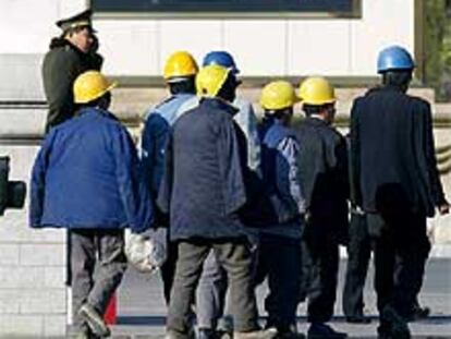Un grupo de trabajadores ante un retrato de Jiang Zemin, ayer en Pekín.