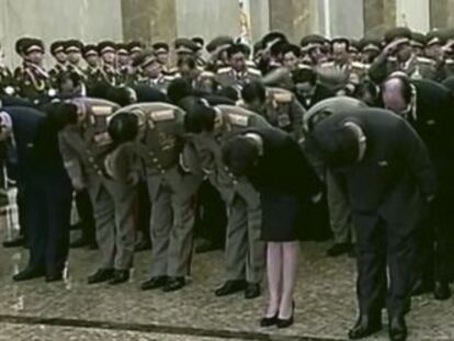 Kim Jong-un (no centro) inclina-se diante da estátua de seu pai.