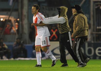 Unos hinchas empujan a Adalberto Román, del River, tras el partido.