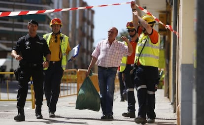 Un vecino sale con sus enseres del edificio colindante al inmueble desplomado en Carabanchel.