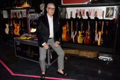 El diseñador Tommy Hilfiger posa rodeado de guitarras de los Stones que se muestra en la exposición.