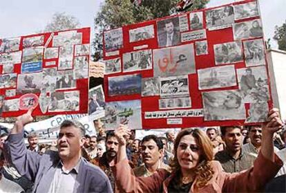 Un grupo de sirios contrarios a la guerra muestran carteles con imágenes que, según los manifestantes, son niños iraquíes heridos en la guerra.