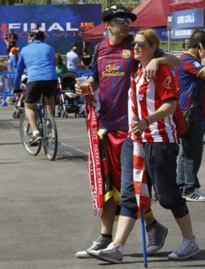Una pareja de aficionados, él de Barcelona y ella del Athletic, pasean esta mañana por Madrid.