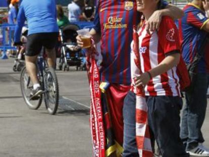 Una pareja de aficionados, &eacute;l de Barcelona y ella del Athletic, pasean esta ma&ntilde;ana por Madrid. 