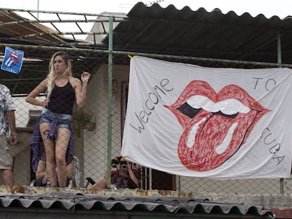 Una cubana mira a los Rolling Stones desde una azotea en La Habana.