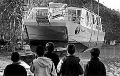 El catamarán <i>La Oca</i> es izado del fondo del lago de Banyoles días después del naufragio.