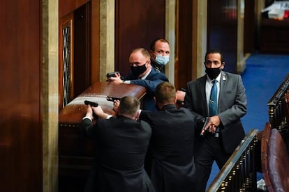 Policías apuntan con sus pistolas para defender la Cámara de los Representantes, este miércoles, en Washington.