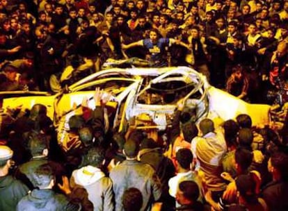 Palestinos observan el coche destruido ayer en un ataque israelí en Gaza, en el que hubo tres muertos.