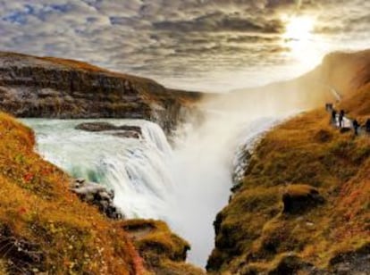 Turistas paseando frente a la cascada de Gullfoss (islandia) en otoño.