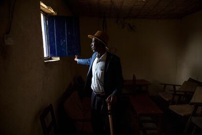 Jean-Bosco Gakwenzire, de 65 años y de etnia tutsi, mira a través de una ventana en su hogar en el sector de Mutete, en la ciudad de Byumba, el 2 de marzo. El padre de Jean-Bosco, su esposa y cuatro de sus seis hijos fueron asesinados en Mutete durante el genocidio ruandés de 1994. Su amigo Pascal Shyirahwamaboko, formó parte de las milicias que mataron a su familia durante el genocidio de 1994.