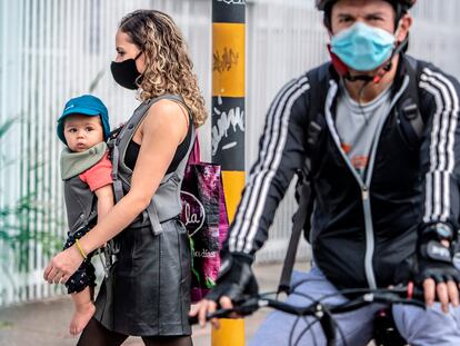 Peatones con mascarillas recorren las calles de Bogotá.