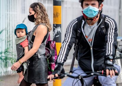Peatones con mascarillas recorren las calles de Bogotá.