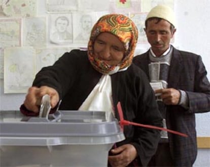 Una mujer de origen albano deposita su voto junto a su marido en Zajac.