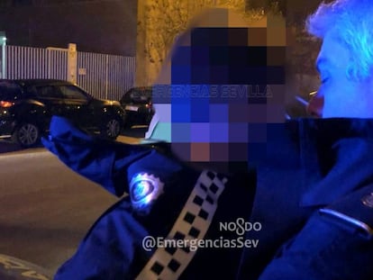 Un policía local de Sevilla lleva en brazos al niño extraviado.