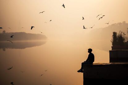 Un hombre contempla el río Yamuna al amanecer, en Nueva Delhi (India).