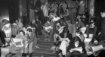 Varios periodistas leen EL PA&Iacute;S en la noche del golpe de Estado fallido del 23-F, en las escaleras del hotel Palace. 