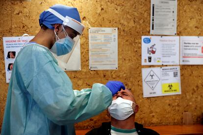 Un sanitario realiza el test serológico a un hombre en el Casal de la Gent Gran Provençana de L'Hospitalet.