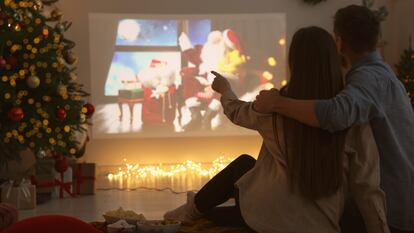 Una pareja viendo una peli con proyector en casa.