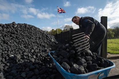 Funcionário maneja carvão durante feira de máquinas a vapor em 17 de abril em Hollycoombe (Inglaterra).