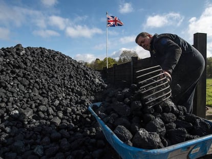Funcionário maneja carvão durante feira de máquinas a vapor em 17 de abril em Hollycoombe (Inglaterra).