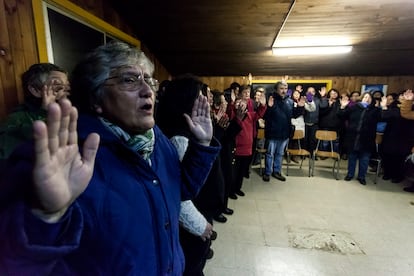 Un grupo de feligreses rezan en un centro comunitario en Osorno.