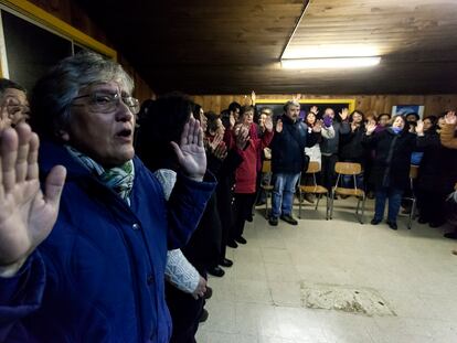 Un grupo de feligreses rezan en un centro comunitario en Osorno.