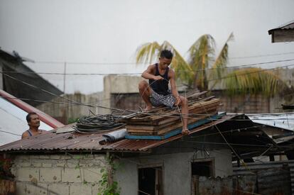 Dos residentes aseguran el techo de sus casas ante la llegada del tifón Mangkhut en Tuguegarao, al norte de Manila.