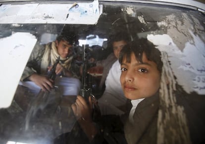 Un grupo de niños portan rifles dentro de un coche para manifestarte contra los ataques saudíes llevados en la capital de Yemen.