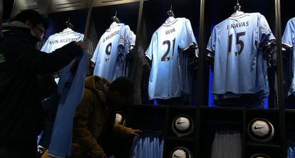 Dos aficionados observan las camisetas del Manchester City en la tienda oficial del club. 