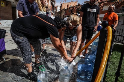 Vecinos llenan garrafas con agua potable, cuyo suministro se ha visto comprometido tras el paso de la Dana.