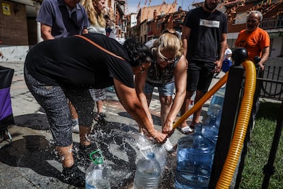 Vecinos llenan garrafas con agua potable, cuyo suministro se ha visto comprometido tras el paso de la Dana. 