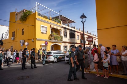 Vecinos y agentes de la Guardia Civill en la  calle Fernando Martín de la localidad sevillana de Guillena, donde han fallecido este domingo cuatro personas de la misma familia. 