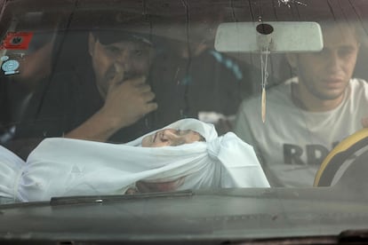 Un niño de la familia al-Zanati, asesinado junto con otros miembros del clan familiar en un ataque israelí, yace en el regazo de un hombre mientras se dirigen al cementerio de Jan Yunis para su entierro, este lunes, en la franja de Gaza.