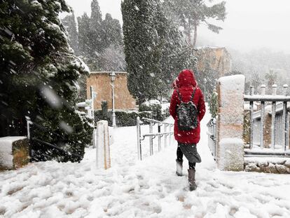 Una persona camina por una calle cubierta de nieve en el pueblo de Valldemossa en la isla de Mallorca.