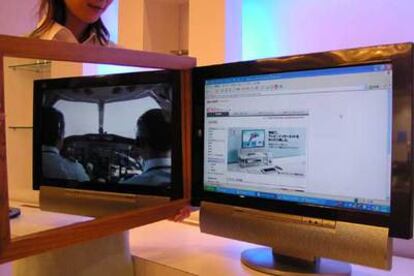 Una empleada de Sharp sostiene un espejo para mostrar las dos imágenes que proyecta la nueva pantalla plana.