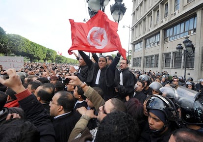 A las nueve comenzaba la marcha, a pesar de que el país estuviera bajo el toque de queda desde el miércoles pasado (de 12 a 6 de la mañana). En la imagen. Un grupo de abogados sujetan la bandera de Túnez ante los miles de ciudadanos congregados enfrente del Ministerio del Interior, en la avenida Habib Bourguiba.