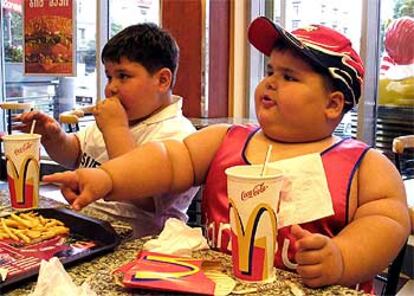 Un niño ruso de cuatro años y 56 kilos junto a otro niño obeso en un establecimiento de comida rápida en Tbilisi (Georgia).