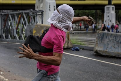Un simpatizante de la oposición al Gobierno lanza una piedra durante una protesta en contra de la gestión de Nicolás Maduro el 28 de junio de 2017, en Caracas.