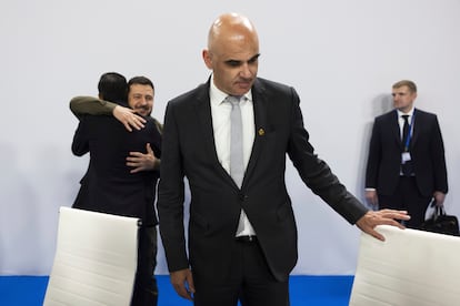 El presidente de Suiza, Alain Berset, toma asiento. Al fondo, Volodímir Zelenski abraza a Rishi Sunak (de espalda).