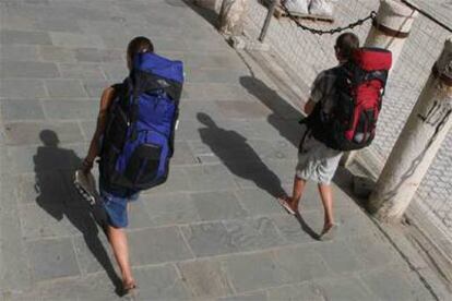 Dos turistas caminan por las calles de Sevilla a mediodía de ayer.