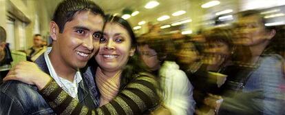 Un boliviano que logró superar el control de pasaportes abraza a su novia, que le esperaba ayer en Barajas.