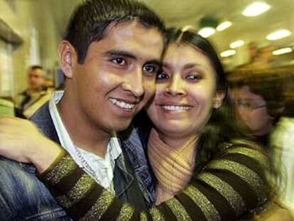Un boliviano que logró superar el control de pasaportes abraza a su novia, que le esperaba ayer en Barajas.