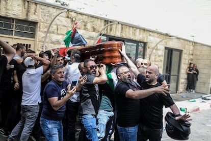 Los porteadores del ataúd de la periodista palestina-estadounidense Shikreen Abu Akleh, a la salida del hospital, antes de iniciarse el cortejo fúnebre.