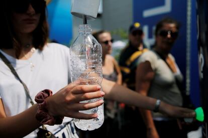 Varias personas hacen cola para rellenar sus botellas de agua en el Salón Internacional de la Aeronáutica y el Espacio de París-Le Bourget, Francia, el 23 de junio de 2019.
