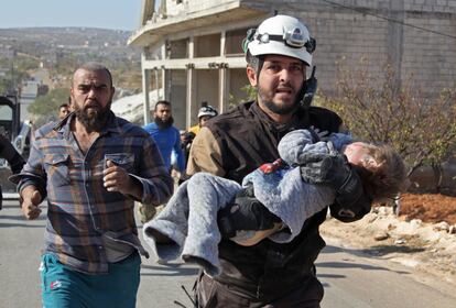 Un miembro de la Defensa Civil siria, también conocida como los Cascos Blancos, lleva a un bebé herido sacado de los escombros de un edificio después de un ataque aéreo reportado por las fuerzas progubernamentales en la aldea de Shinan (Siria).